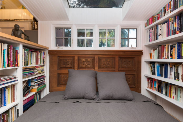 кровать в окружении книг